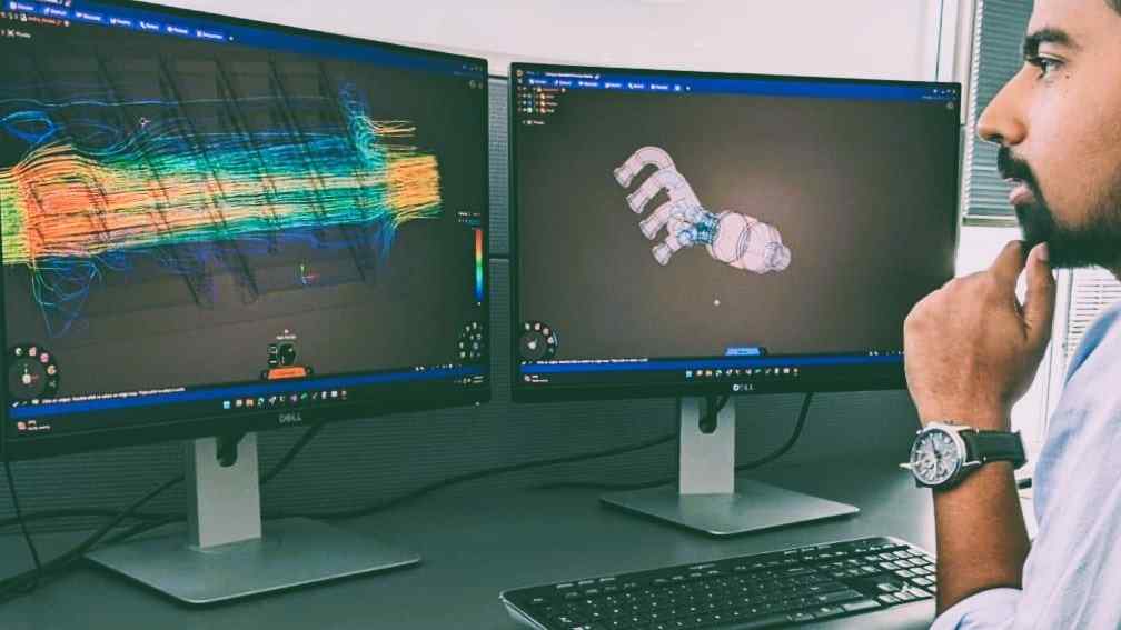 photograph of a rocket scientist using Ansys Discovery at an office desk with two monitor setup